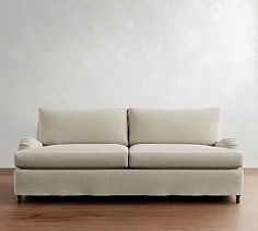 a white couch sitting on top of a wooden floor