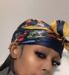 a woman wearing a bandana and piercings