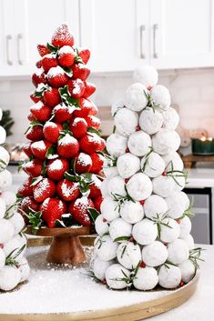 three christmas trees made out of snowballs and strawberries on a table in a kitchen