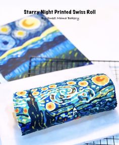 starry night printed swiss roll is on the table next to another rolled up piece of fabric