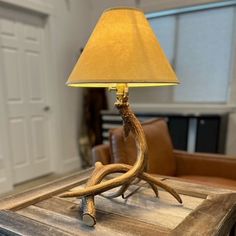 a lamp that is sitting on top of a wooden table in front of a couch