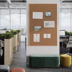 an office with a cork board and various seating areas