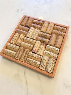 a wooden box filled with wine corks on top of a marble countertop next to a bottle opener