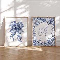 two blue and white flowers are on the wall next to each other, one with a bow