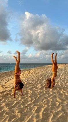 two women doing handstands on the beach