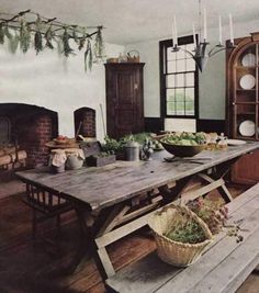 an old fashioned kitchen with wooden table and benches