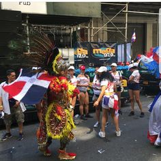 some people are walking down the street with flags on their heads and headdress