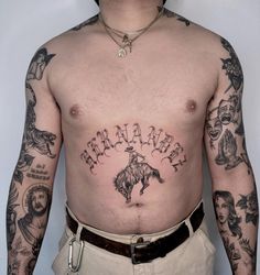 a man with many tattoos on his stomach and chest is standing in front of a white wall