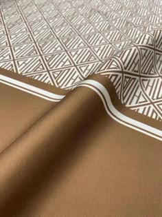 a close up view of a brown and white pattern on a bed sheet that is laying down