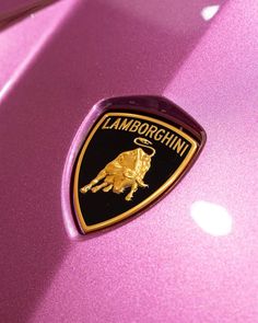 a lamb emblem on the hood of a pink car