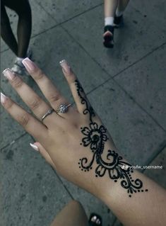 a woman's hand with henna tattoos on it