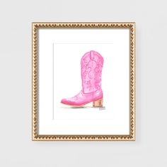 a pink cowboy boot is framed in a gold frame on a white wall next to a painting