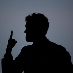 the silhouette of a man pointing at something in the air with his finger to his side