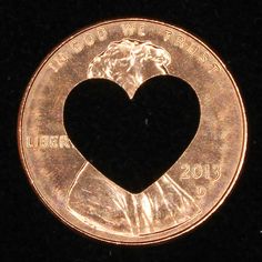 a penny with a heart shaped hole in it