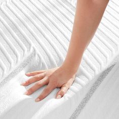 a person's hand on top of a mattress