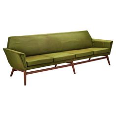 a green couch sitting on top of a wooden frame