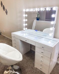 a white chair sitting in front of a desk with a mirror on top of it