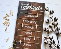 a wooden sign sitting on top of a table next to dried flowers and clothes pins