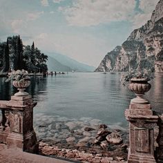 an old photo of a lake with mountains in the background