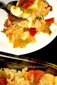 a white plate topped with rice covered in meat and veggies next to a fork