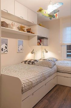 a bed room with a neatly made bed next to a shelf filled with stuffed animals