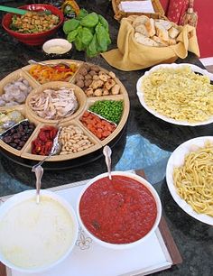 a table topped with plates of food and bowls of sauces on top of it