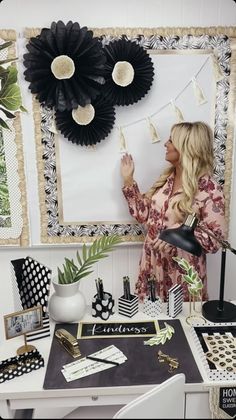 a woman standing in front of a desk with black and white decorations