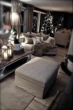 a living room filled with lots of furniture and christmas trees in the window sill