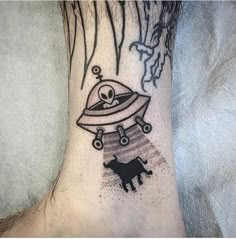 a black and white tattoo on the foot of a person with a dog in space