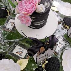 a table topped with a black and white cake covered in flowers