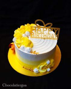 a yellow and white birthday cake with flowers on it