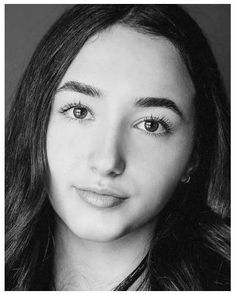 a black and white photo of a young woman with long hair, wearing a necklace