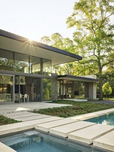 a modern house with an outdoor pool in the foreground