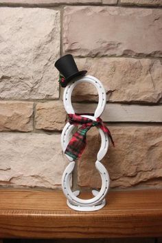 a white and black hat on top of a wooden shelf next to a brick wall