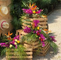 three wooden crates filled with different types of flowers and greenery next to each other