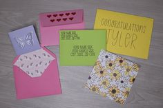 four cards with congratulationss on them sitting on top of a wooden table next to each other