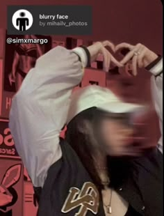 blurry image of a person wearing a white shirt and black hoodie with his hands in the air