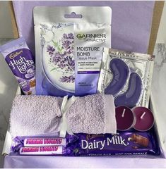 an open box containing purple items and candles