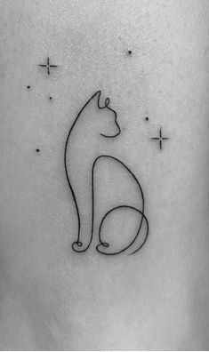 a black and white cat tattoo on the back of a woman's leg, with stars in the background