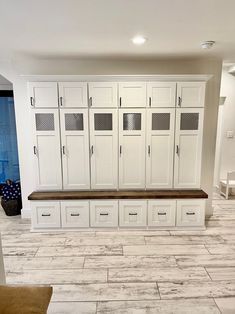 a kitchen with white cabinets and tile flooring