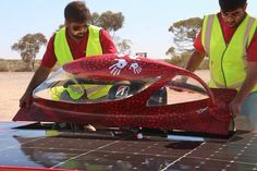 two men working on a solar powered vehicle