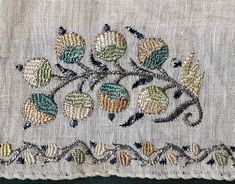 a piece of cloth with embroidered flowers on it