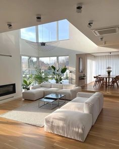 a living room filled with furniture and a fire place in the middle of a floor to ceiling window