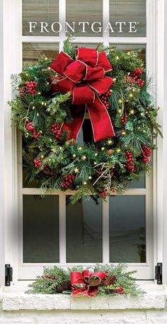 a christmas wreath is hanging on the window sill in front of a white door