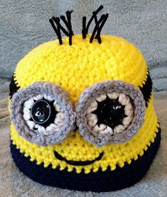 a crocheted yellow and black hat with eyes