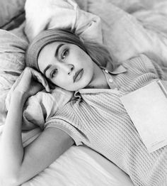 a black and white photo of a woman laying in bed