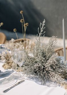 the table is set with silverware, flowers and candles for an elegant dinner party