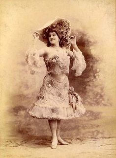 an old fashion photo of a woman in a dress and hat with flowers on her head