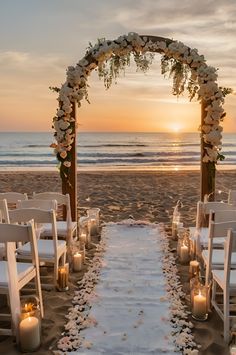 an outdoor wedding setup on the beach with candles and flowers in front of the ocean