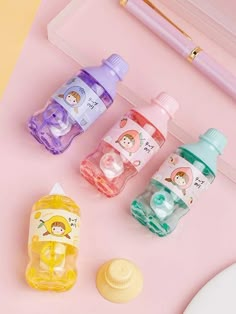 three baby bottles sitting on top of a pink table